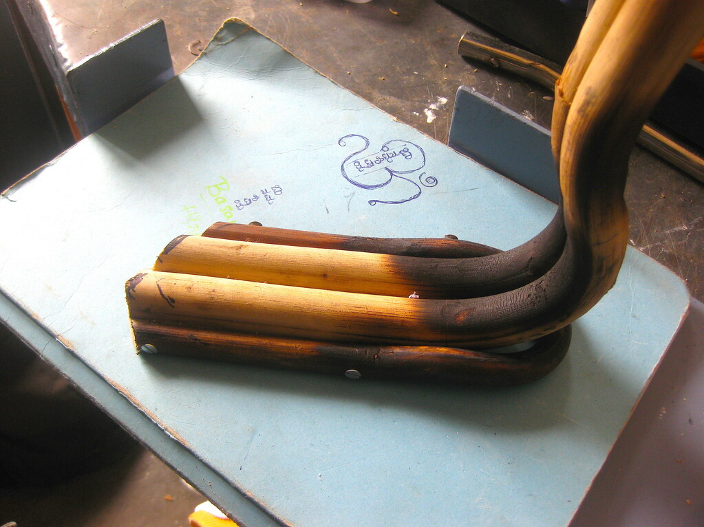 The curved foot extends from the lower leg, sticks of cane bound together.